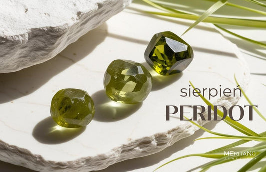 Peridot leżący na białym kamieniu, obok liście trawy Peridot leżący na białym kamieniu, obok liście trawy