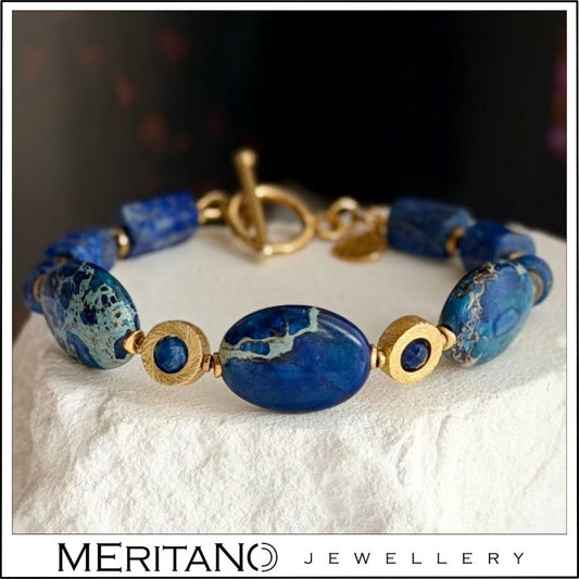 Bransoletka z lapis lazuli, jaspisem i kianitem, niebieskie kamienie naturalne, srebro pozłacane leżąca na gipsie z przodu Bransoletka z lapis lazuli, jaspisem i kianitem, niebieskie kamienie naturalne, srebro pozłacane leżąca na gipsie z przodu