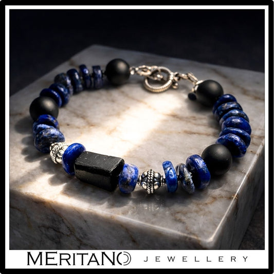 Bransoletka męska z turmalinem i lapis lazuli ze srebrem oksydowanym, leżąca na kamieniu Bransoletka męska z turmalinem i lapis lazuli ze srebrem oksydowanym, leżąca na kamieniu