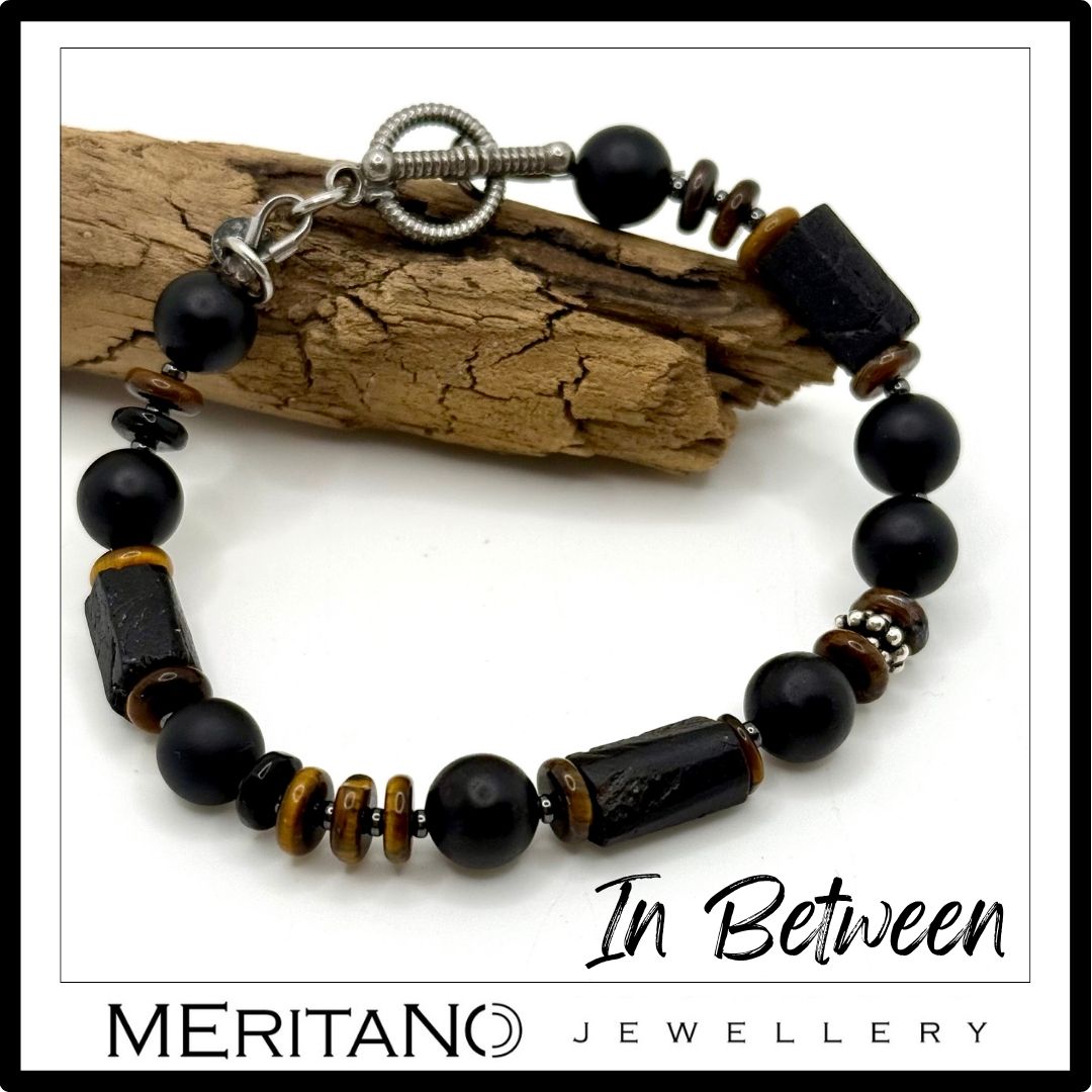 Bransoletka męska z kamieni czarny turmalin i tygrysie oko - widok z góry koło drewna