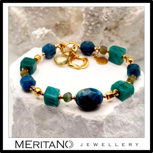 Bransoletka z kamieni naturalnych amazonitu i apatytu leżąca na białym kamieniu Bransoletka z kamieni naturalnych amazonitu i apatytu leżąca na białym kamieniu