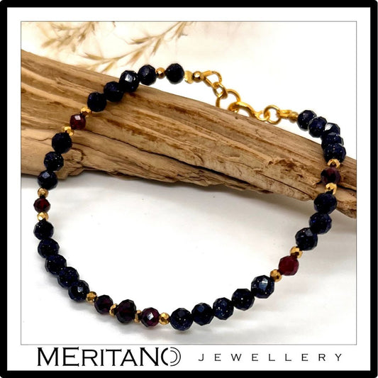 Cienka bransoletka z kamieni z naturalnym granatem i nocą Kairu koło drewna Cienka bransoletka z kamieni z naturalnym granatem i nocą Kairu koło drewna