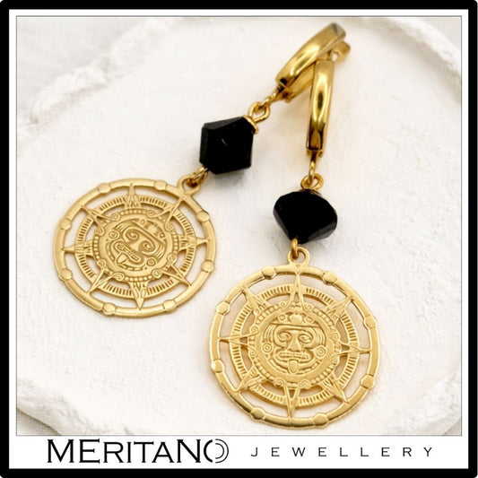 Czarno złote kolczyki z turmalinem, wiszące, zapięcie angielskie leżące na białym gipsie Czarno złote kolczyki z turmalinem, wiszące, zapięcie angielskie leżące na białym gipsie