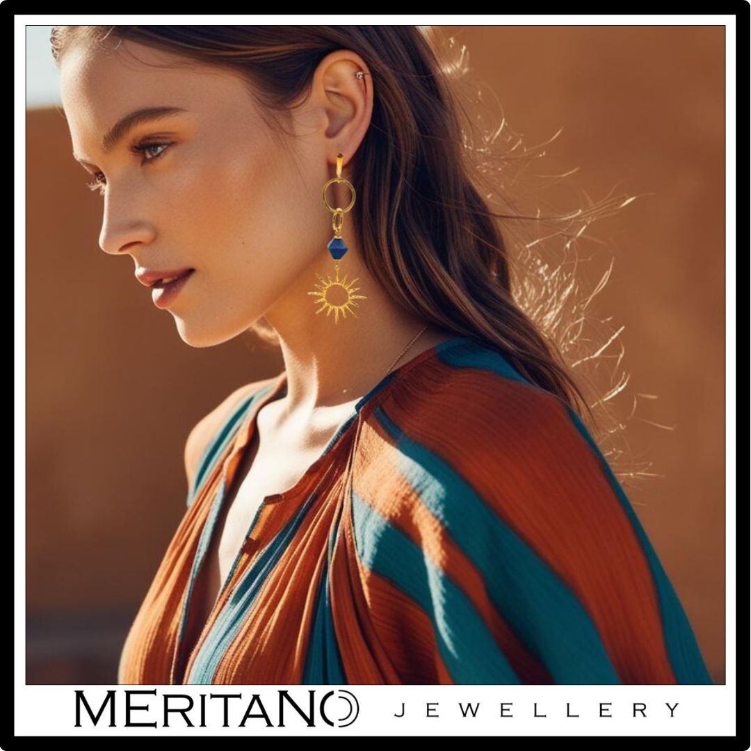 Kolczyki wiszące z lapis lazuli ze złotym motywem słońca noszone na uchu, widoczna proporcja i długość