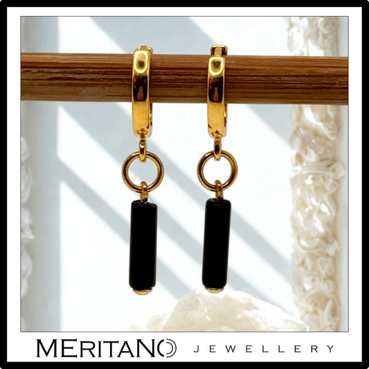 Złote kolczyki z onyksem na biglu. Widok z przodu. Złote kolczyki z onyksem na biglu. Widok z przodu.