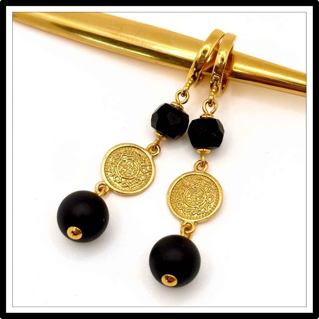 Wiszące kolczyki z turmalinem i monetą. Widok z góry