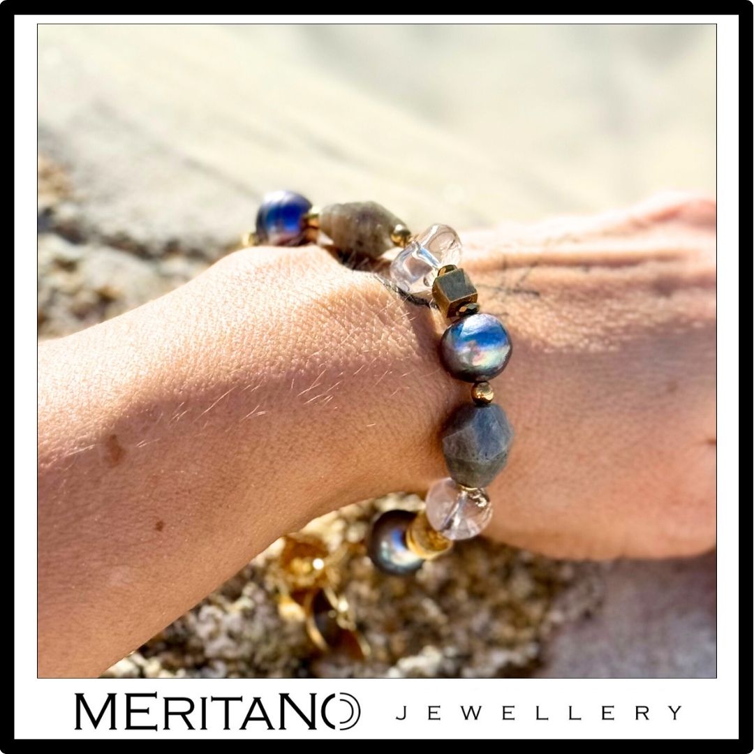 Bransoletka z zielonymi perłami barokowymi, labradorytem i kryształem górskim w złotej oprawie, uchwycona na nadgarstku w naturalnym świetle | Meritano Jewellery.