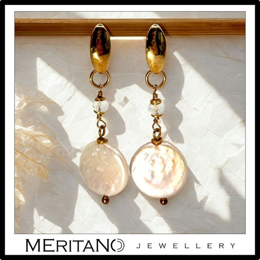 Długie złote kolczyki z perłami. Widok z przodu Długie złote kolczyki z perłami. Widok z przodu