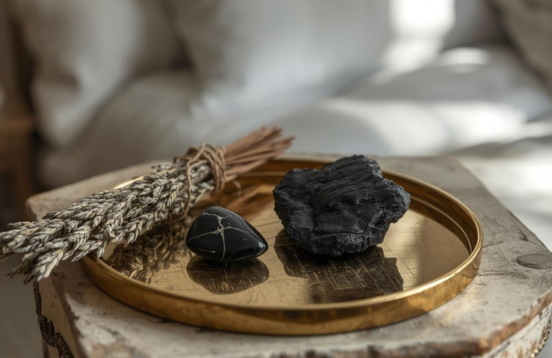 Kamienie ochronne – czarny turmalin i onyks ułożone na złotej tacy z naturalnymi trawami, symbol ochrony i spokojnego snu.