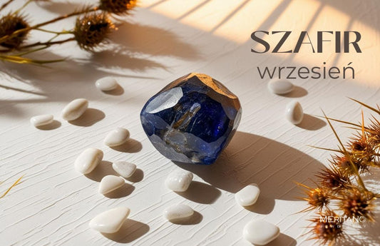 Kamień szafiru leżący na jasnym tle obok suszonych gałązek i białych kamyczków