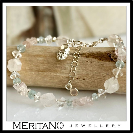 Bransoletka z niebieskich i różowych kamieni dla przyszłej mamy - leżąca na drewnie