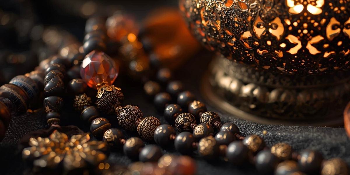 Złota lampa na ciemnym materiale, obok naszyjnik z czarno złotych kamieni - kompozycja Meritano Jewellery do kolekcji biżuterii Magia Orientu