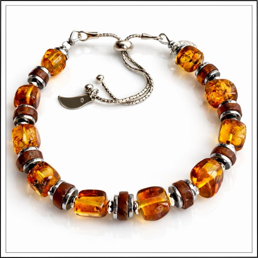 Srebrna bransoletka z bursztynem naturalnym i granatem hessonit na białym tle