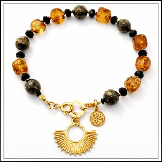 Bransoletka z bursztynem i pirytem ze złotą zawieszką na białym tle