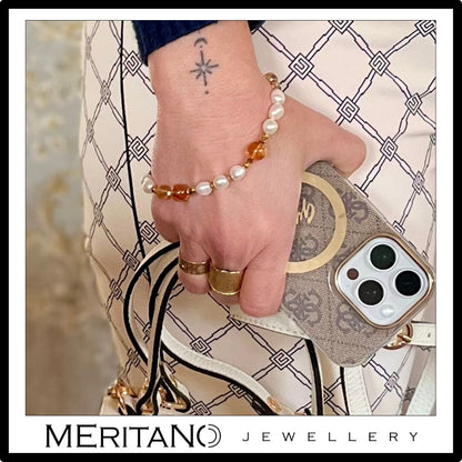 Bransoletka do telefonu z pereł i cytrynów - widok na ręce przy telefonie