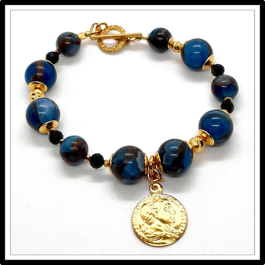 Bransoletka z jaspisem i obsydianem, ze złotą zawieszką. Widok z góry.