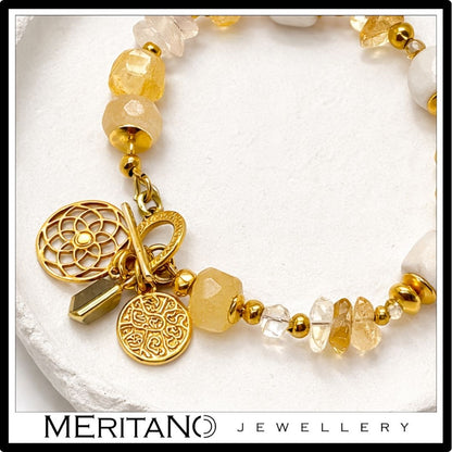 Bransoletka z kamieniem księżycowym i cytrynem, ozdobiona zawieszką, leżąca na kamieniu  - zbliżenie