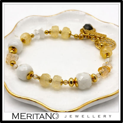 Bransoletka z kamieniem księżycowym i cytrynem, ozdobiona zawieszką, widok na białej tacy