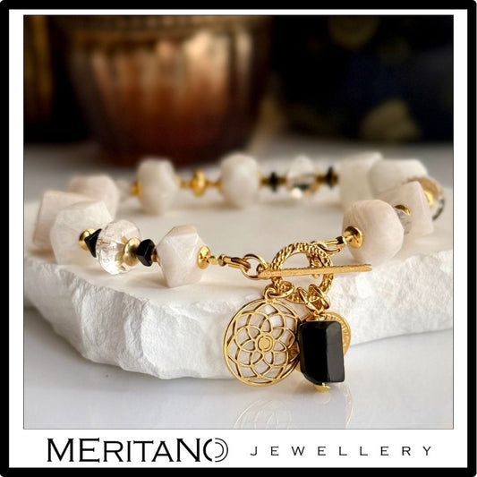 Bransoletka z kamieniem księżycowym i kryształem górskim, ze złotymi zawieszkami - widok z przodu na jasnym kamieniu Bransoletka z kamieniem księżycowym i kryształem górskim, ze złotymi zawieszkami - widok z przodu na jasnym kamieniu