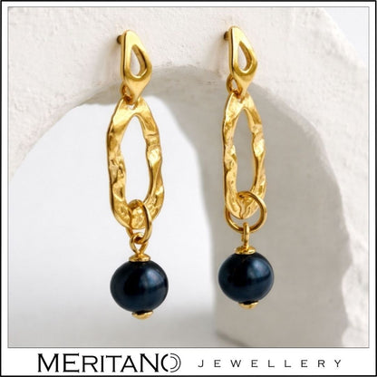 Złote kolczyki z czarną perłą - widok z boku