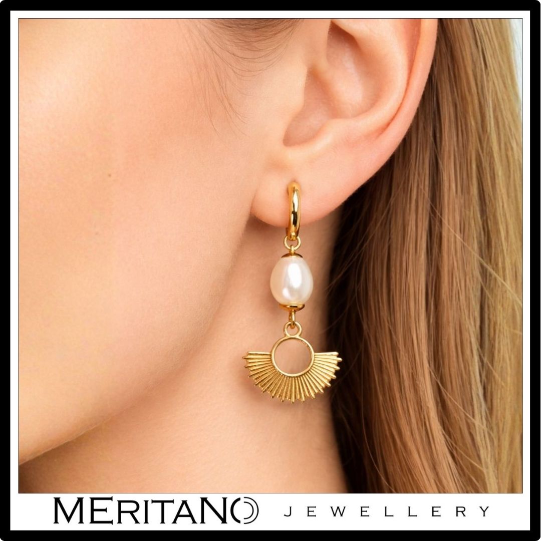 Wiszące kolczyki złote z perłami na uchu