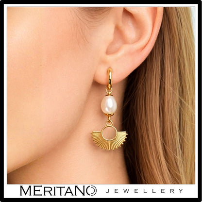 Wiszące kolczyki złote z perłami na uchu