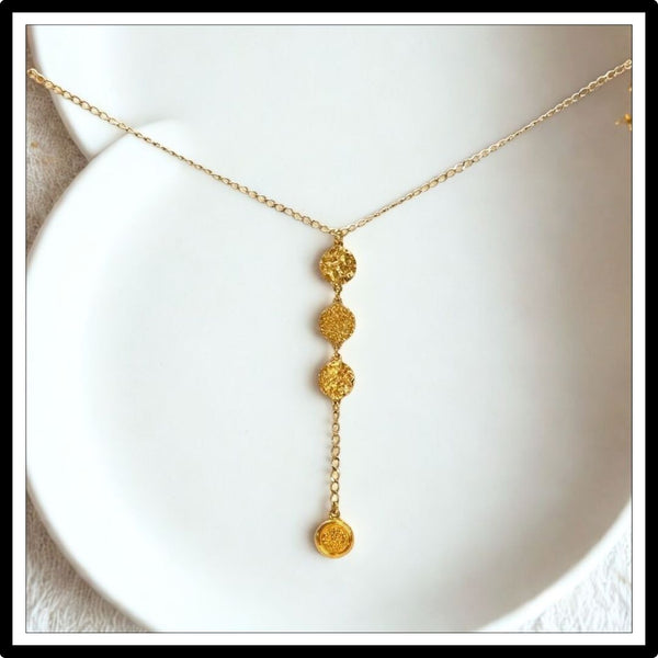 Złoty łańcuszek krawatka z monetami - widok z przodu na białym tle