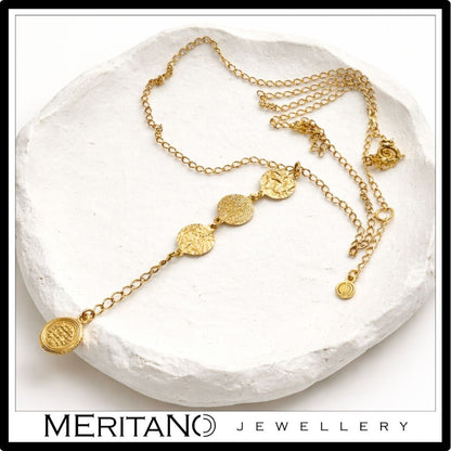 Złoty łańcuszek krawatka z monetami -leżący na gipsowej tacy