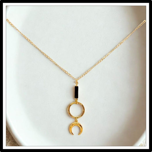 Złoty łańcuszek krawatka z onyksem i księżycem. Widok z przodu na białym tle