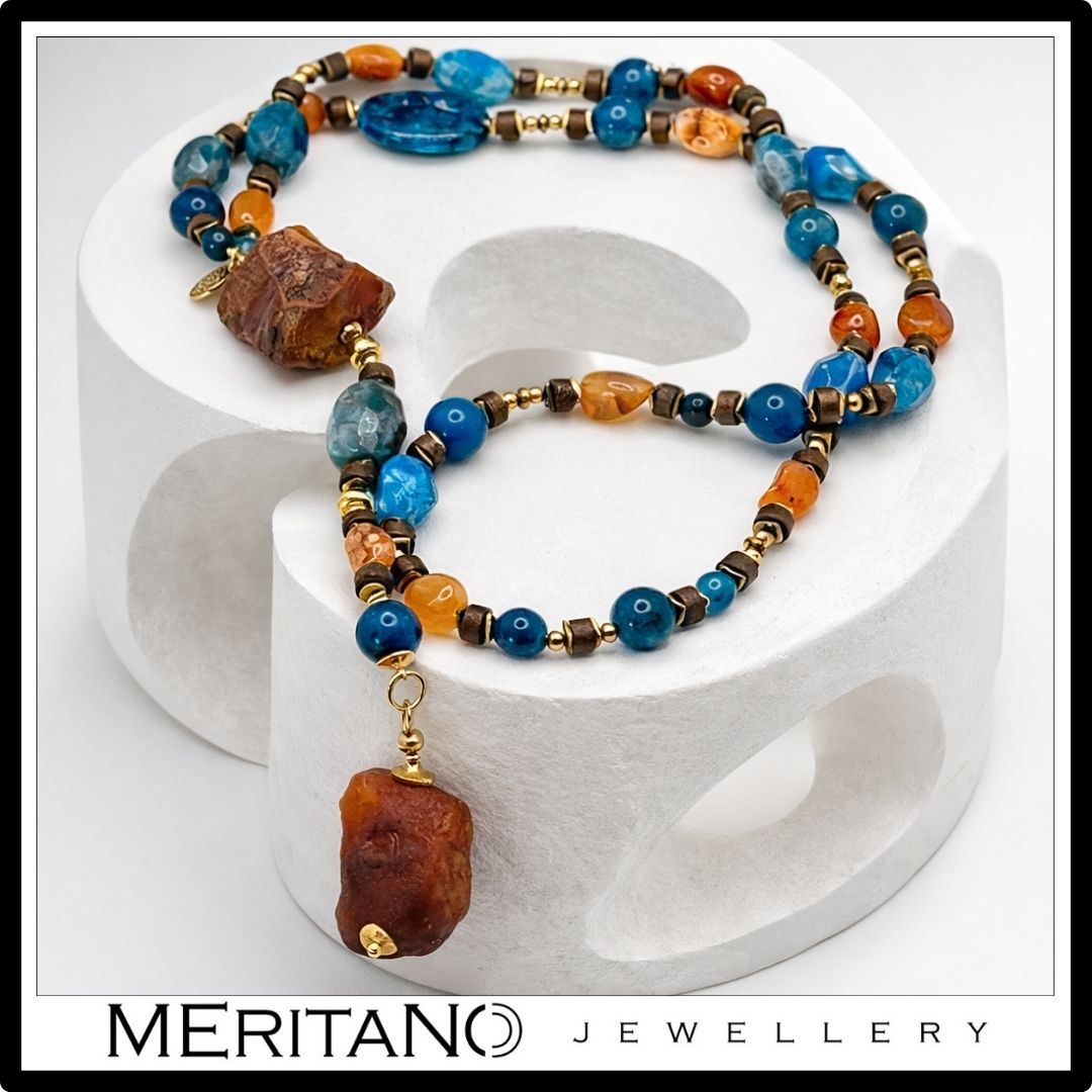 Naszyjnik z agatem i apatytem, długi naszyjnik krawatka z dużych kamieni leżący na białym kształcie