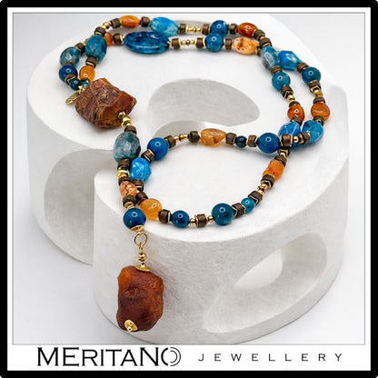 Naszyjnik z agatem i apatytem, długi naszyjnik krawatka z dużych kamieni leżący na białym kształcie