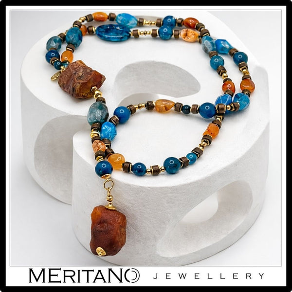 Naszyjnik z agatem i apatytem, długi naszyjnik krawatka z dużych kamieni leżący na białym kształcie