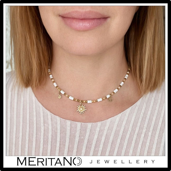 biały naszyjnik z kamieni naturalnych cytryn, howlit, słońce na szyi modeli w białej bluzce