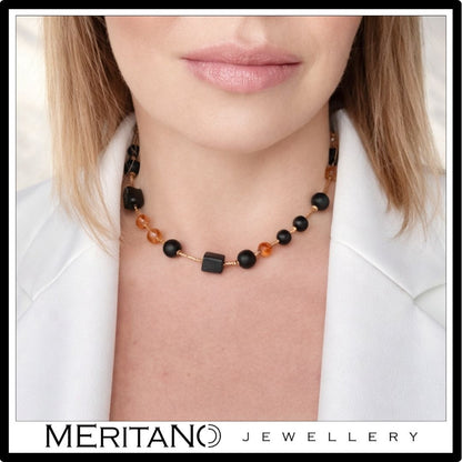 Krótki naszyjnik z czarnym turmalinem i cytrynem, choker na szyi modelki w białej marynarce