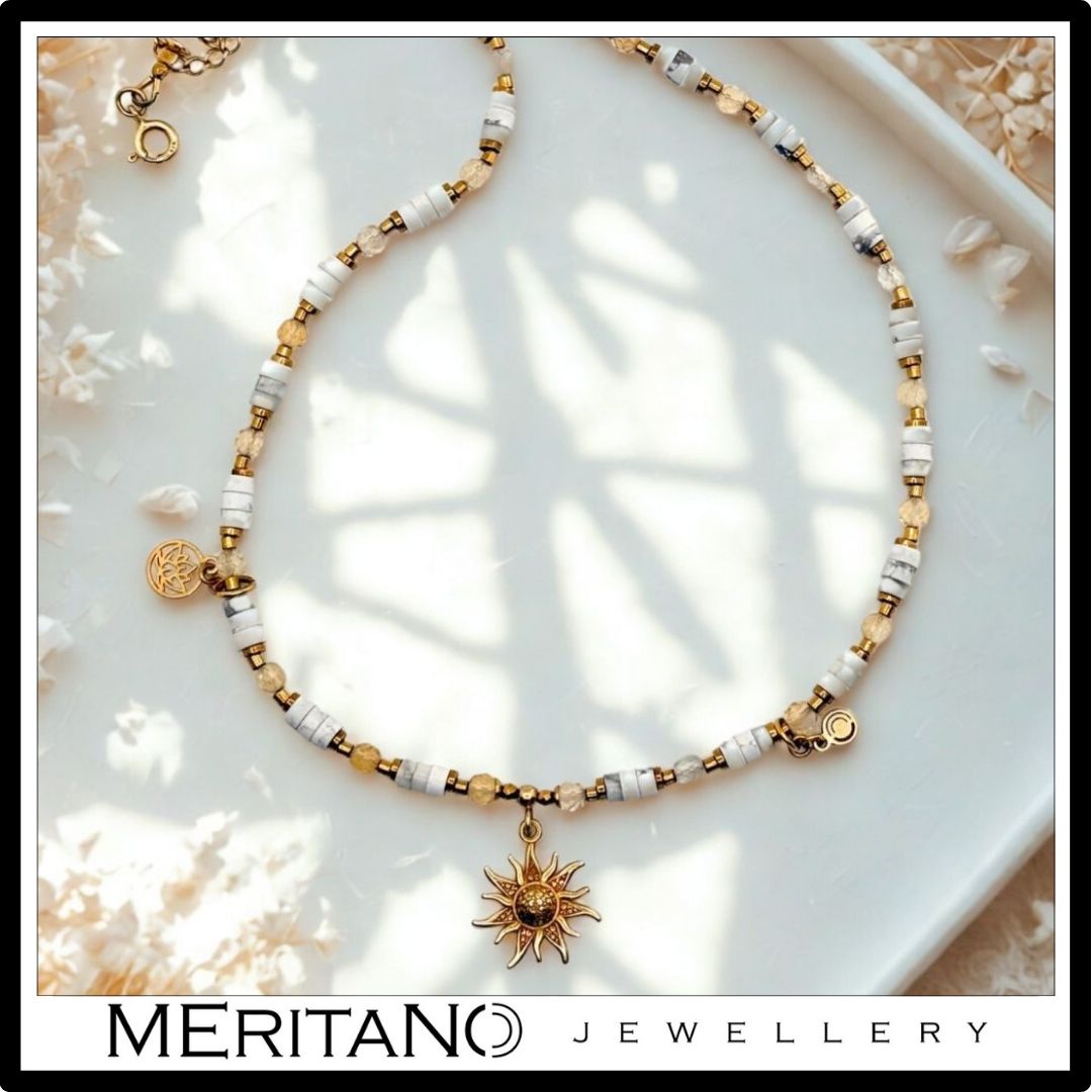 Naszyjnik howlit i cytryn ze złotą zawieszką słońce. Widok z góry.