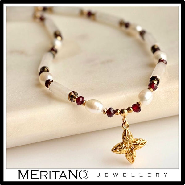 Krótki naszyjnik z jadeitem, perłami i granatem, ze złotą zawieszką.