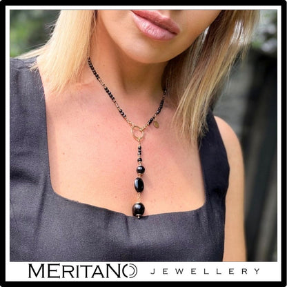 Naszyjnik krawatka z turmalinem i onyksem - widok na szyi modelki w czarnej bluzce