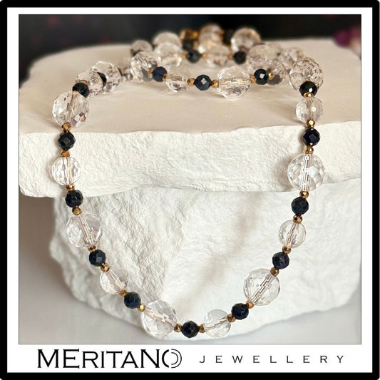 Naszyjnik z kryształem góskim i szafirem, kolia, leżący na białym kamieniu