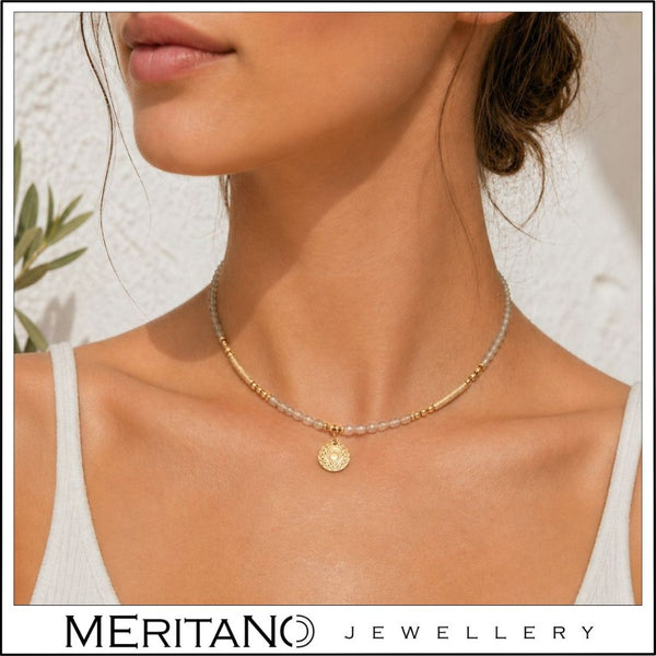 Naszyjnik z labradorytem i czakrą gardła na szyi modelki w białej stylizacji