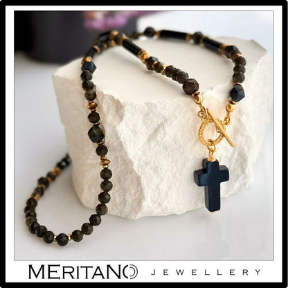 Naszyjnik onyks, obsydian na zapięciu toggle leżący na białym kamieniu