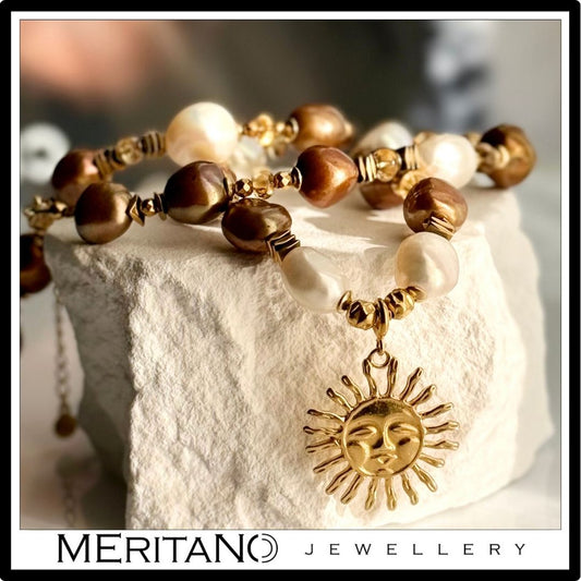 Naszyjnik z pereł barokowych ze złotą zawieszką słońce - projekt Meritano Jewellery. Widok na kamieniu Naszyjnik z pereł barokowych ze złotą zawieszką słońce - projekt Meritano Jewellery. Widok na kamieniu