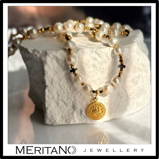 Naszyjnik z pereł naturalnych z monetą. Widok na białym kamieniu Naszyjnik z pereł naturalnych z monetą. Widok na białym kamieniu