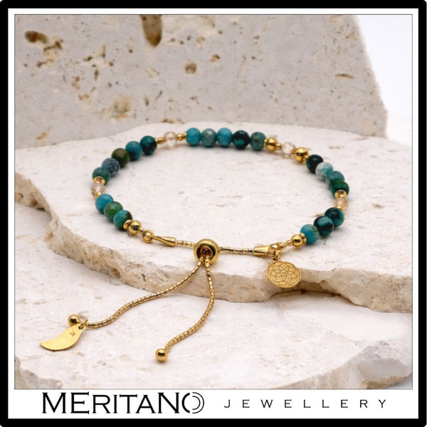 Bransoletka z turkusem i cytrynem, niebieskie kamienie i złote dodatki, leżąca na trawertynie