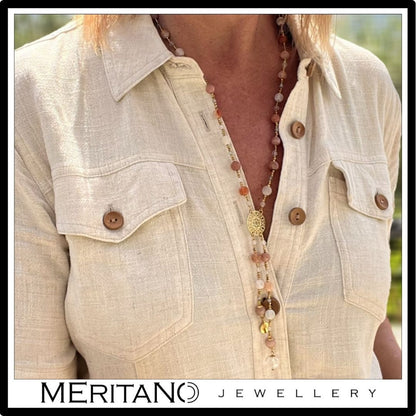 Długi naszyjnik z różowym kamieniem agatem, labradorytem i rozetą. Widok na szyi.