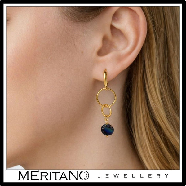 złote wiszące kolczyki z perłami na uchu