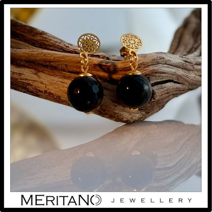 Kolczyki z onyksem czarno złote, wiszące - widok obok drewna