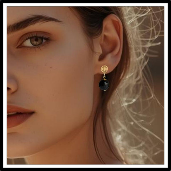 Wiszące kolczyki z onyksem, czarno-złote na uchu