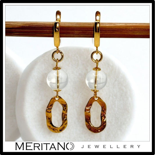 Złote kolczyki z kryształem górskim. Widok z przodu.