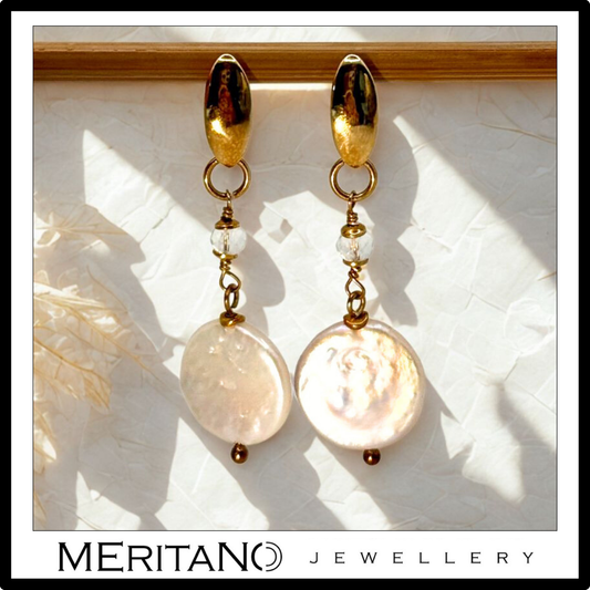 Długie złote kolczyki z perłami. Widok z przodu Długie złote kolczyki z perłami. Widok z przodu