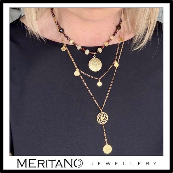 Złoty łańcuszek z monetami z innymi naszyjnikami - widok na szyi